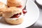 Tasty scones with clotted cream and jam on plate