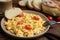 Tasty scrambled eggs with cherry tomato and bread on wooden table