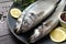 Tasty sea bass fish with spices on dark wooden table, closeup