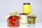 Tasty seasoned vegetables in jars. Kitchen pantry with mortar. W