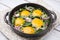 Tasty Shakshouka in frying pan on white wooden table, closeup