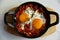 Tasty Shakshouka served in pan on white marble table, top view