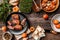 Tasty snack with cheese, peach, prosciutto slices and capers, microgreen,on wooden table, view from above, place for text