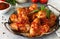 Tasty snack close-up. Baked chicken wings with mustard tomato sauce