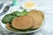 Tasty spinach pancakes on white marble table