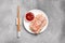 Tasty spring rolls with sauce and chopsticks on grey textured table, flat lay