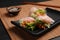 Tasty spring rolls served with soy sauce on grey table, closeup