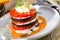 Tasty stack of fried eggplants and tomatoes on spicy sauce served at plate