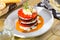 Tasty stack of fried eggplants and tomatoes on spicy sauce served at plate