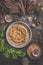 Tasty stuffed savory pastry pie with phyllo dough in traditional baking pan on dark rustic background with ingredients.  Top view