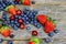 tasty summer fruits on a wooden table. Blueberries Grape Strawberries Blackberries