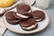 Tasty sweet choco pies on light gray table, closeup