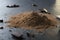 Tasty sweet pieces of chocolate and heap of cocoa powder on the dark table, close up