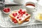 Tasty sweet toasts with raspberries and cup of tea on vintage tray