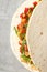 Tasty taco on grey textured background, close up