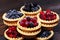 Tasty tartlets with different berries,cranberries,bilberry,blackcurrant . Berry tartlets. Cake with berries. Dessert with berries