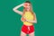 Tasty tropical fruits! Attractive sexual woman in bright sport clothes holding fresh juicy grapefruit or orange near face on isola