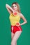 Tasty tropical fruits! Attractive sexual woman in bright sport clothes holding fresh juicy grapefruit or orange near face on isola