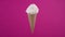 Tasty vanilla ice cream in waffle cone. Sweet dessert, rotating soft cream, gelato icecream scoop over pink background