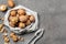 Tasty walnuts with nutcracker on grey table