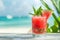 Tasty watermelon cocktail in a clear glass on a stunning and sunny beach setting