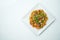 Tasty wok rice in sweet and sour sauce with vegetables and pork meat in a white plate on a gray background. Top view with copy