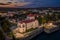 Tata, Hungary - Aerial view of the beautiful illuminated Castle of Tata by the Old Lake Ã–reg-to at dusk with colorful clouds