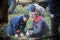 Tatarstan, Russia - 25 august 2018 - Old men sitting in a forest and fixing the chainsaw