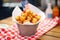 tater tots in a basket with a red and white napkin