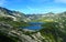 Tatra mountains in Poland, green hill, lake and rocky peak in the sunny day with clear blue sky