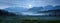 the Tatras veiled in haze, framed by dense forest and rural fields under the shimmering glow of a full moonlit night