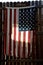 Tattered american flag on fence