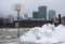 Tattered basketball hoop with melting snowbank with foggy downtown Toronto in mild January weather