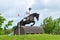 Tattersalls horse show in Ireland, black horse jumping over obstacle with male rider, jockey
