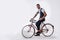 Tattoed elegant man cycling on bicycle