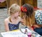 Tattoo artist doing temporary henna tattoo on the hand of the girl