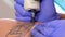 Tattoo artist make a black tattoo on man\'s skin with a tattoo machine. Close up