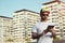 Tattooed bearded young man with a tablet in city