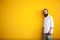 Tattooed fashion bearded hipster on yellow wall