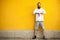 Tattooed fashion bearded hipster on yellow wall