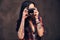 Tattooed girl taking a photo looking at camera in a studio.