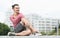 Tattooed man doing yoga stretching exercise outdoors