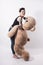 Tattooed natual looking woman playing with giant teddy bear