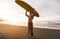 Tattooed senior surfer holding surf board on the beach at sunset - Happy old guy having fun doing extreme sport - Joyful elderly