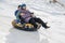 TAU SAMALY, KAZAKHSTAN - DECEMBER 23, 2023: happy Kazakhs family tubing down a slide in winter with snow at Tau Samaly