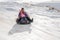 TAU SAMALY, KAZAKHSTAN - DECEMBER 23, 2023: happy Kazakhs family tubing down a slide in winter with snow at Tau Samaly