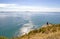 Tauranga, New Zealand. Hiker sitting resting enjoying Panoramic sea view from Mount Maunganui. Tauranga is a major cruise ship out