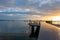 Tauranga waterfront pier and railing reflecting golden glow of morning sunrise