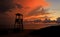 Tawny cloudy sunset silhouetting life guard post watch tower