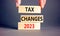 Tax changes 2023 symbol. Concept words Tax changes 2023 on wooden blocks on a beautiful grey table grey background. Businessman